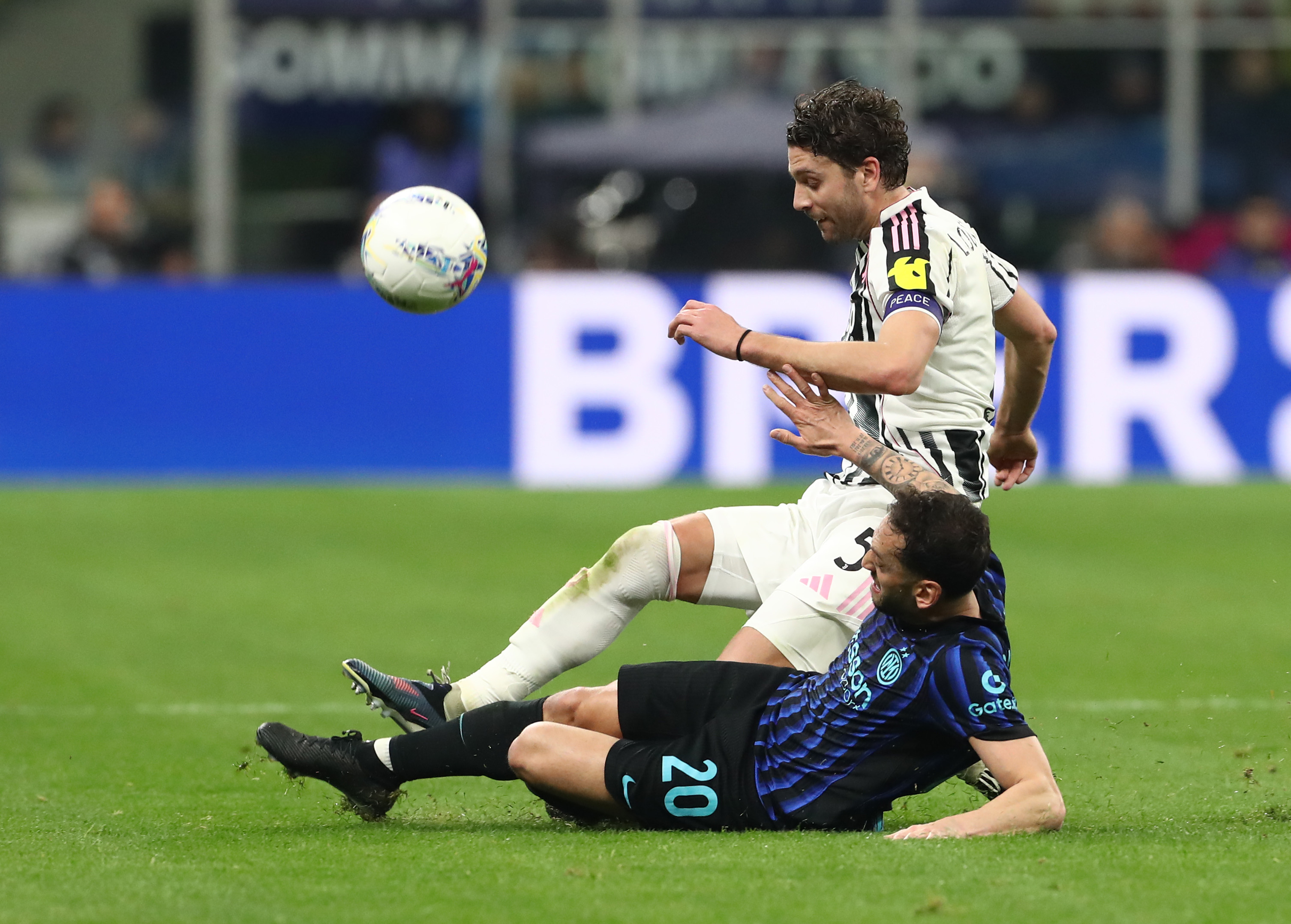 Manuel Locatelli challenging Hakan Calhanoglu for the ball