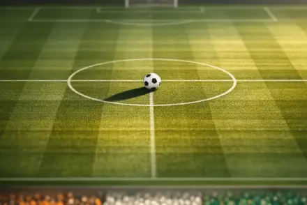 Overhead stadium view of football pitch with ball on centre spot, golden floodlights, orange-white-green colour palette from Ivorian flag.