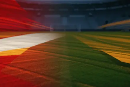 Floodlit stadium pitch at sunset, empty field with Czech and South African flag-colour lighting, dramatic shadows.
