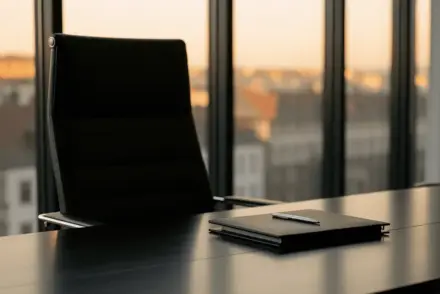 Empty executive boardroom chair at polished conference table with Turin cityscape visible through windows