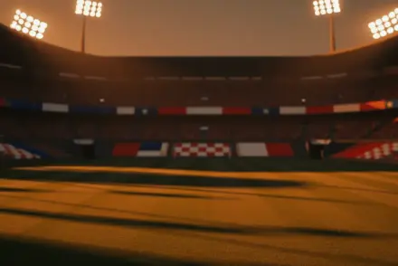 Floodlit stadium pitch at golden hour with dramatic shadows, packed stands, red, white, and blue atmospheric lighting.