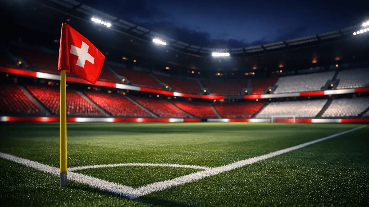 Empty stadium corner section with red-white accent lighting, pitch markings sharp in foreground, evening floodlights