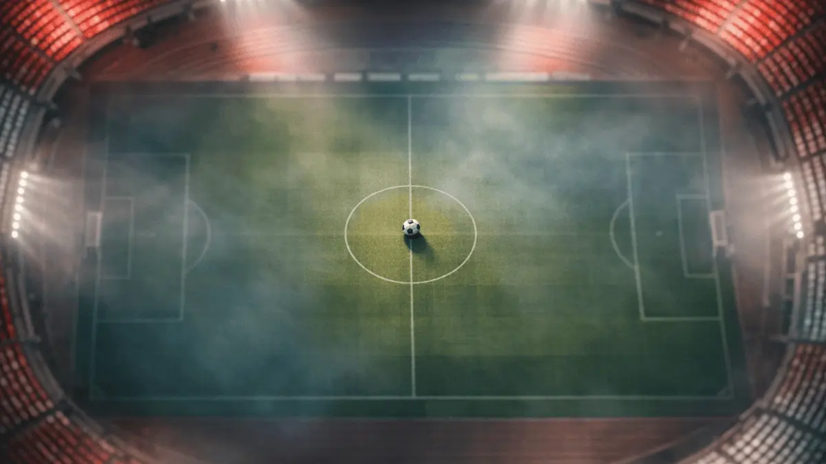 Floodlit stadium pitch from above at dusk, crimson and white atmospheric lighting, centre ball in focus, cinematic sports photography.