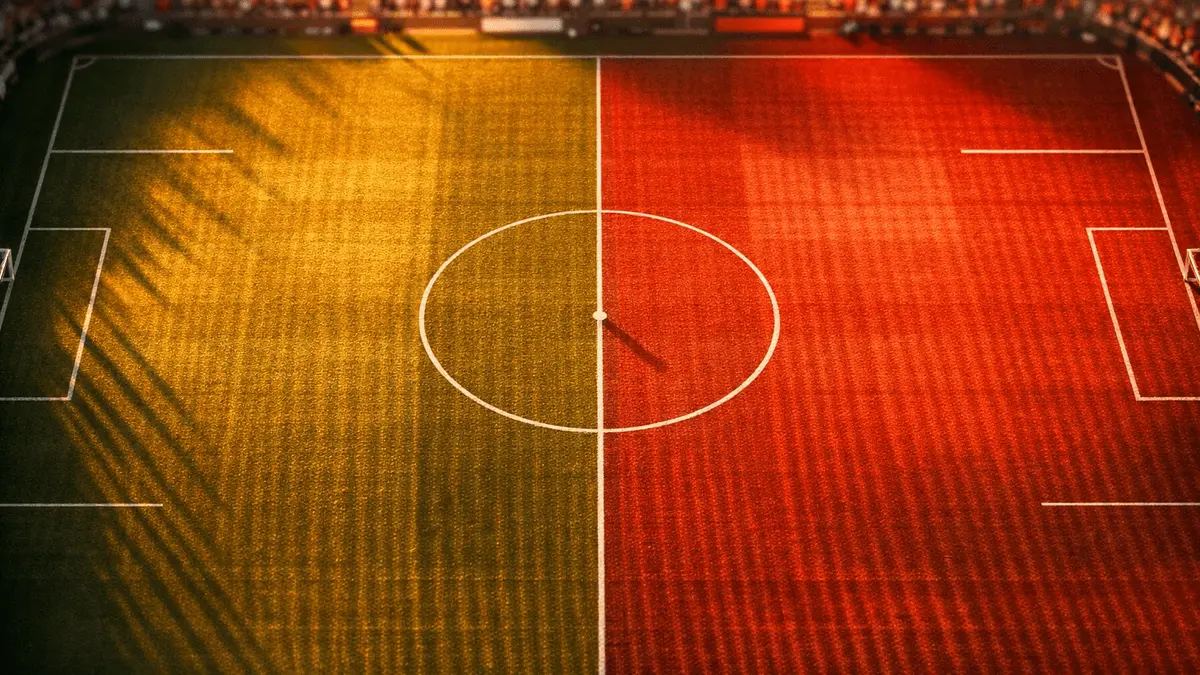 Overhead floodlit football pitch with centre circle and halfway line, red and white strategic lighting, golden-hour shadows, broadcast gantry angle.