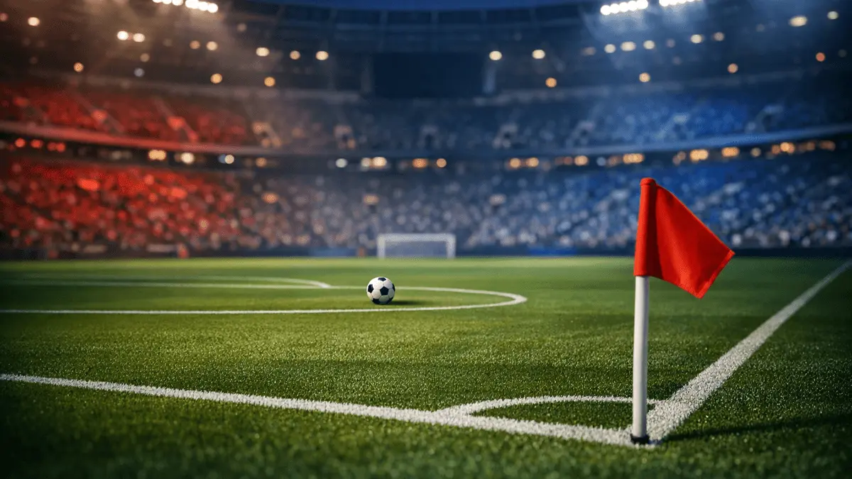 Aerial stadium view at dusk with floodlit pitch, corner flag foreground, centre-circle ball, blue-red lighting, geometric shadows.