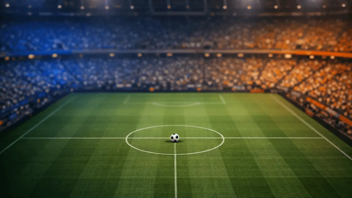 Overhead floodlit stadium view at dusk with centre circle in focus, amber and blue atmospheric lighting, no people or branding visible.