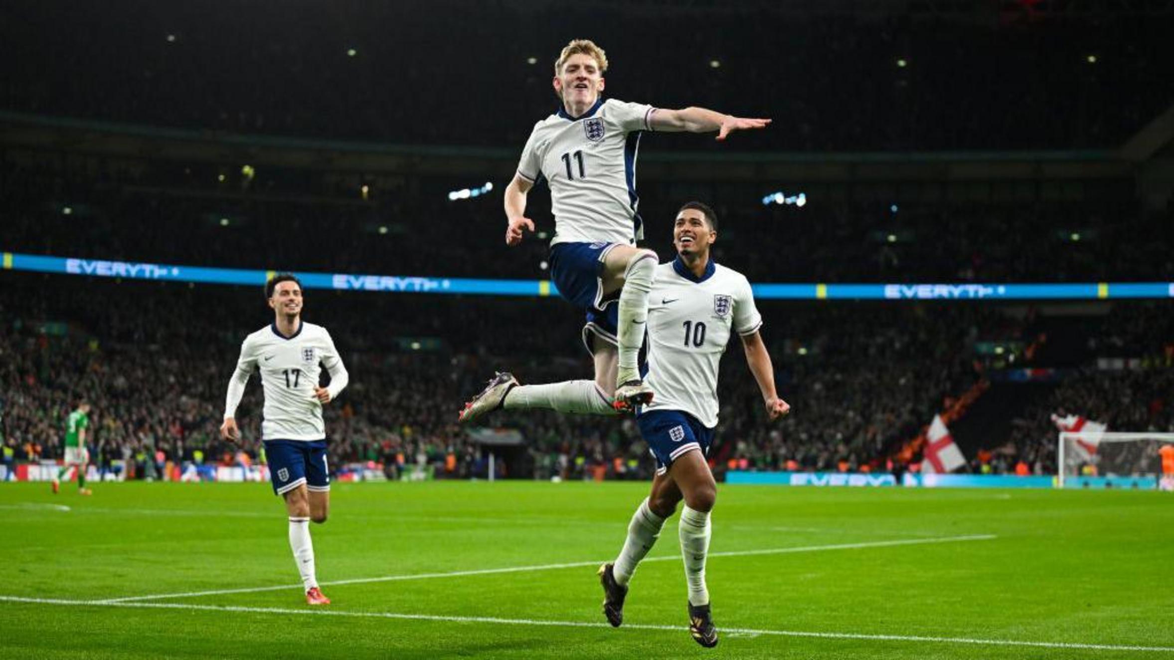 Anthony Gordon celebrating a goal for England, surrounded by teammates.