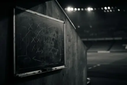 Empty tactical board in shadowy stadium showing crossed formations and strategic markings
