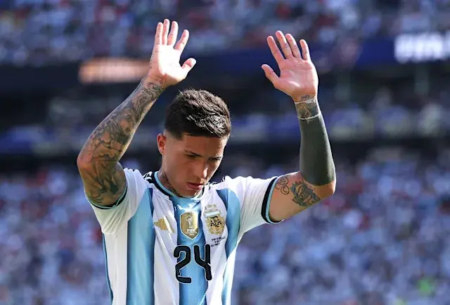 Enzo Fernandez in Argentina national team jersey raising hands during a match.