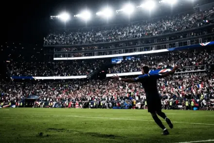 France player celebrating at night under floodlights during World Cup quarter-final at Gillette Stadium
