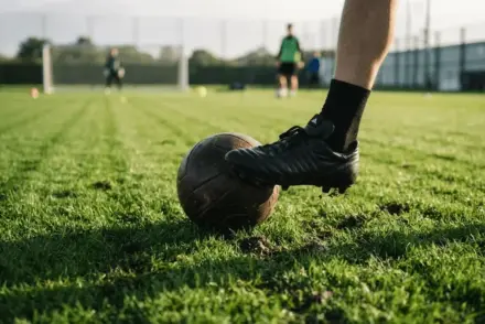 Football boot controlling ball on stadium turf, tactical precision close-up