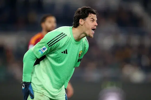 Um goleiro da Roma gritando durante uma partida, vestindo uma camisa verde clara.