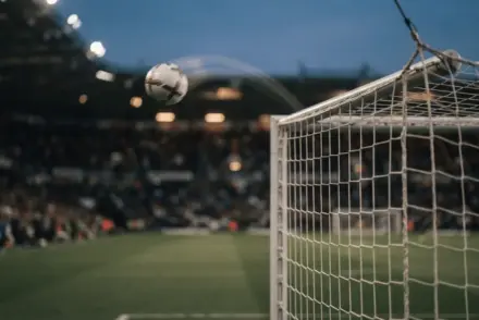 Football curving toward goal during free-kick in professional stadium