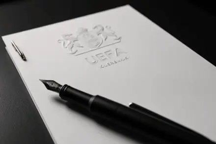 UEFA document on desk representing financial settlement and regulatory sanctions