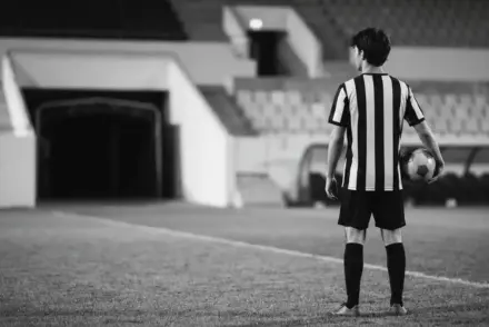 Young striker in a monochrome football setting symbolising Pellegrino's potential transfer to Fiorentina