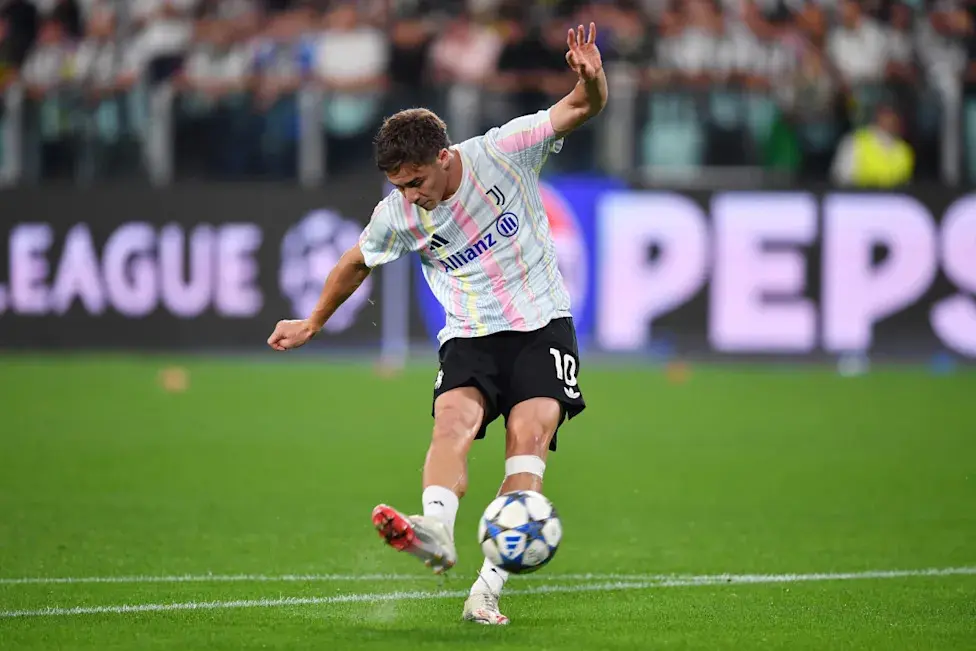 Kenan Yildiz in a Juventus kit kicking a soccer ball during a match