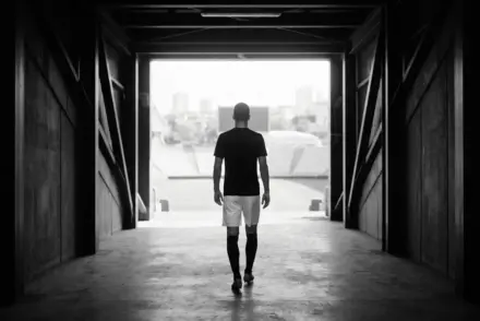 Striker walking through a stadium tunnel toward a new club destination