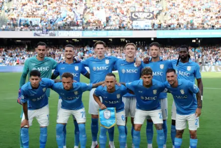 A group of Napoli football players posing for a team photo on the pitch at Stadio Diego Armando Maradona.