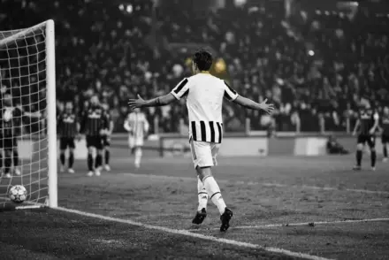 Juventus winger celebrates scoring against Atalanta in a dramatic monochrome stadium scene