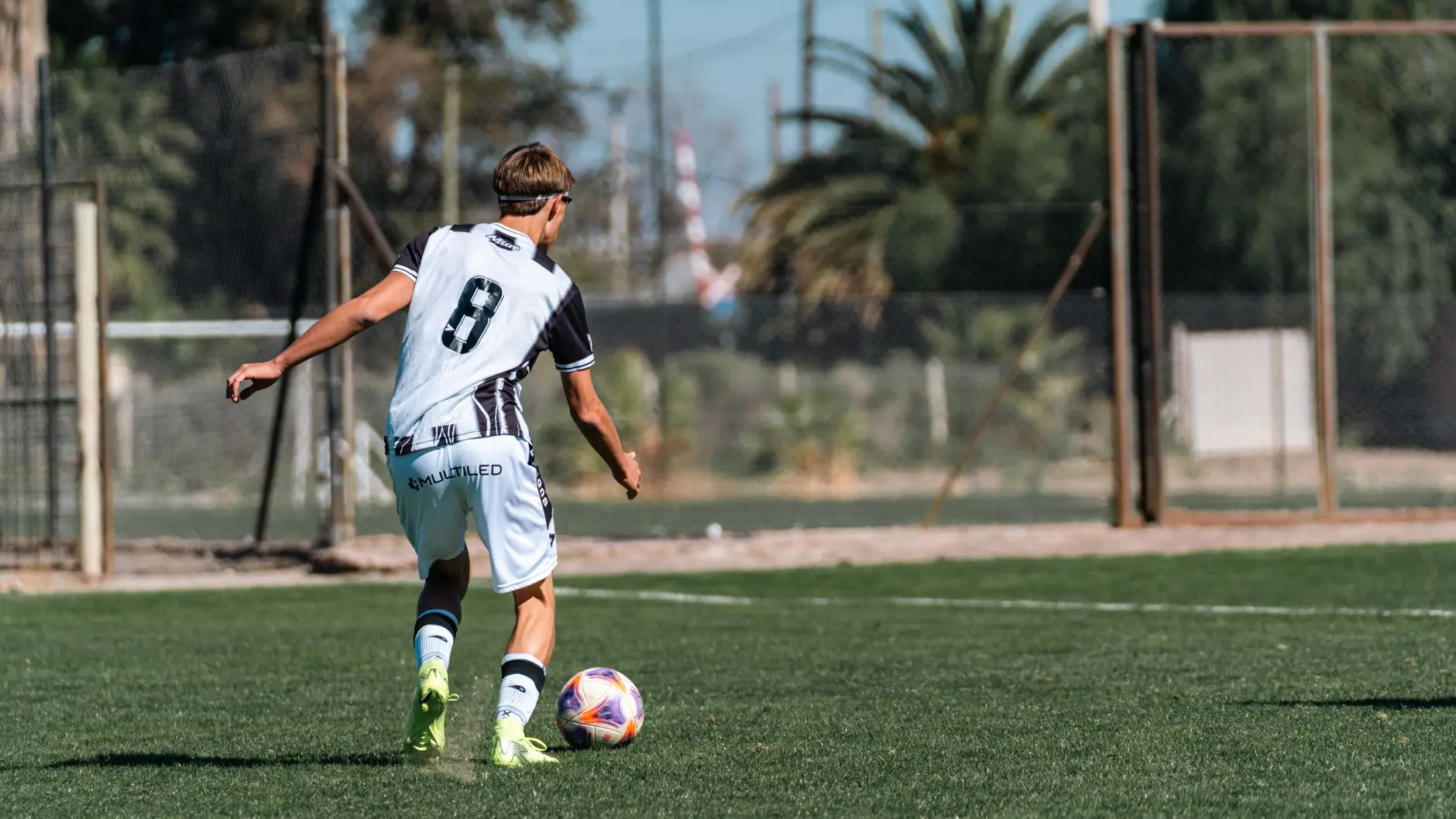 Nick Woltemade wearing a Juventus training kit with number 8 on the back, playing soccer on a grass field