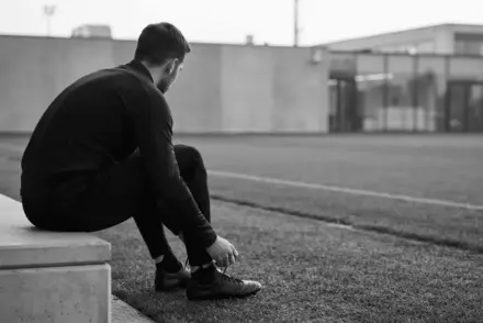 Anonymous footballer undergoing recovery work on a quiet training pitch